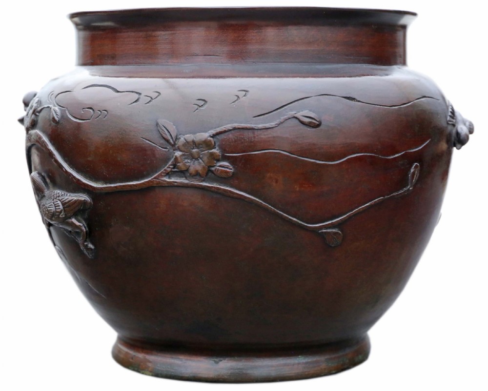 A dark brown bronze Japanese Meiji period jardiniere with high-relief castings of birds resting on prunus branches. View III