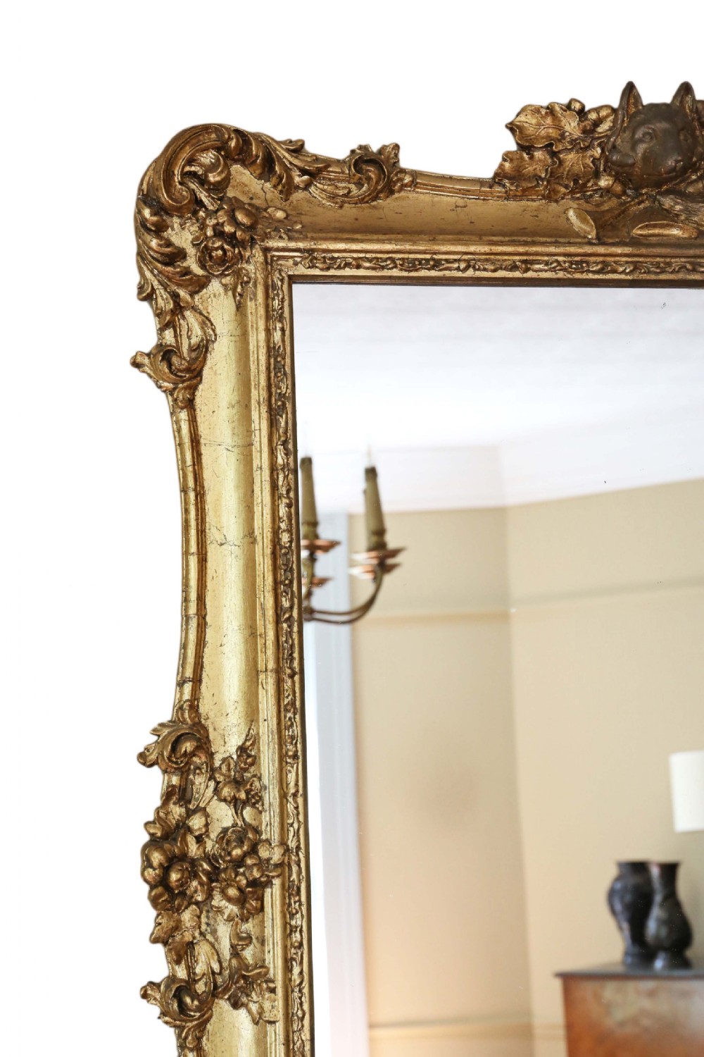 A 19th-century rectangular giltwood overmantle mirror featuring rococo scrollwork ornamentation and a central carved fox head crest at the top. View III