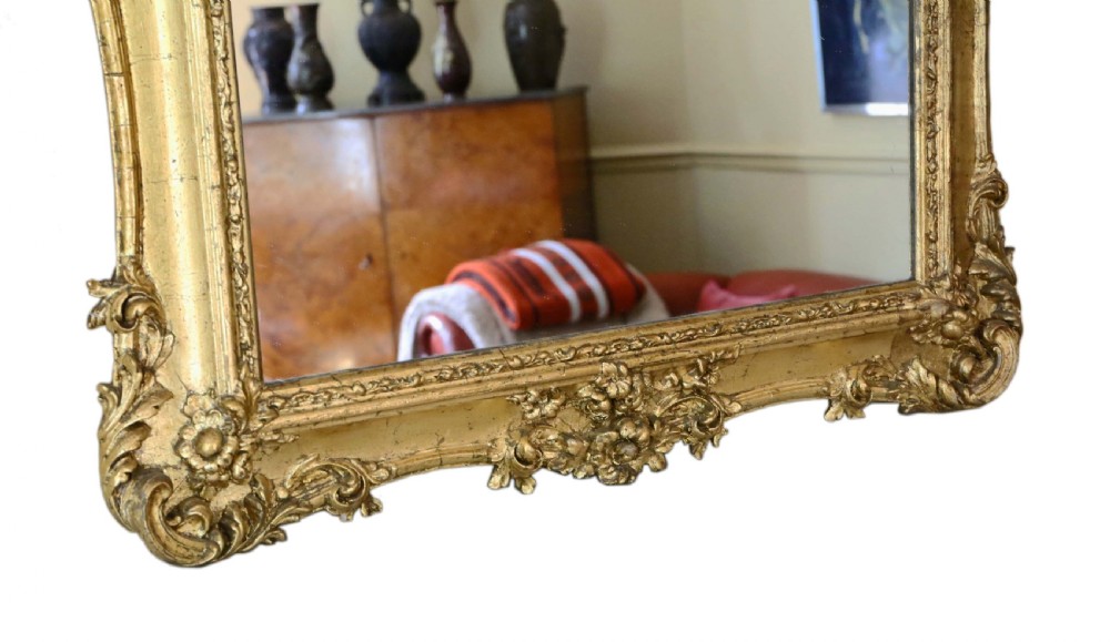 A 19th-century rectangular giltwood overmantle mirror featuring rococo scrollwork ornamentation and a central carved fox head crest at the top. View IV