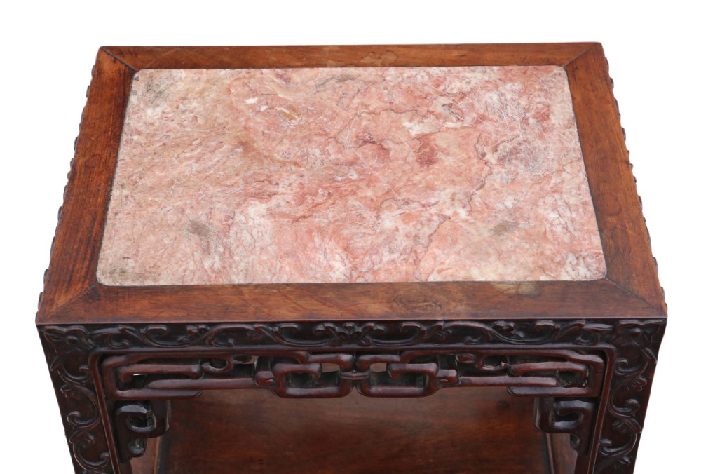 A 19th-century Chinese dark hardwood side table featuring a square inset pink marble top, carved apron, and two lower open shelves. View VII