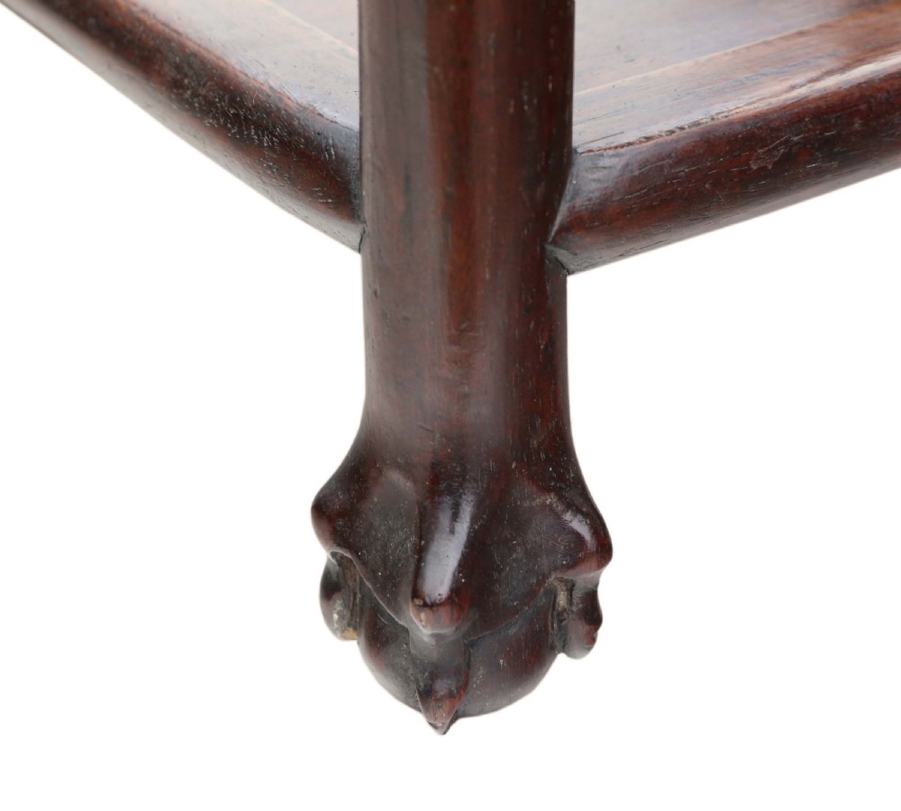 A 19th-century Chinese dark hardwood side table featuring a square inset pink marble top, carved apron, and two lower open shelves. View X