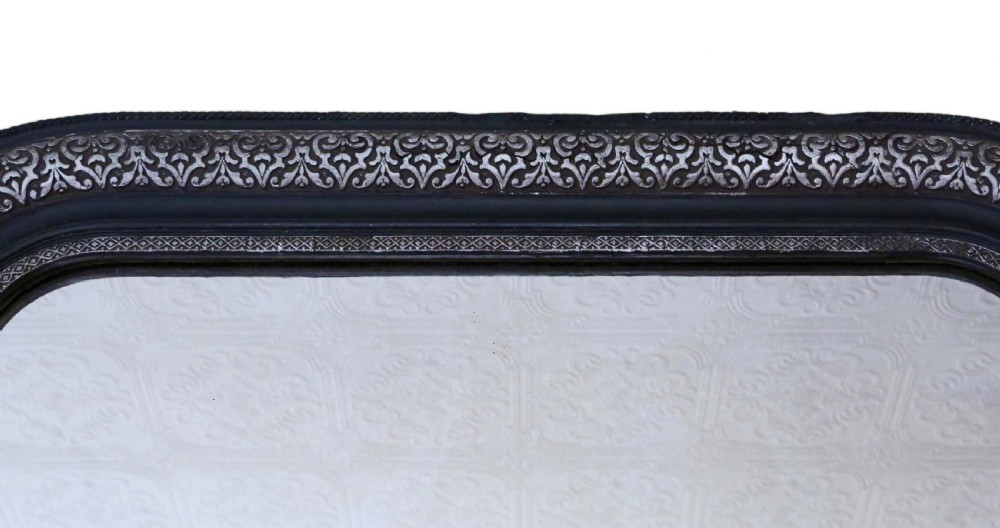 A large late 19th-century rectangular wall mirror featuring rounded top corners, an ebonised outer frame, and an embossed silver gilt inner border. View III