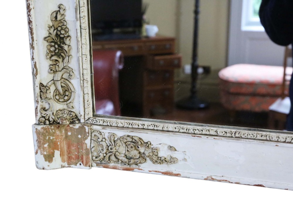 A large nineteenth-century rectangular French overmantle mirror with a cream-painted frame featuring moulded floral scrollwork details and a distressed finish. View V