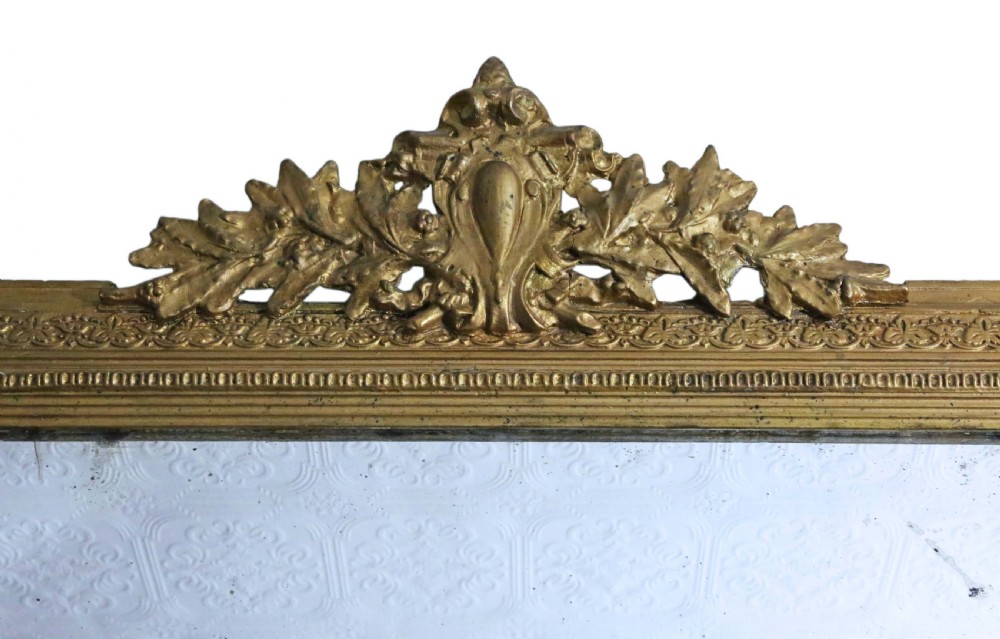 A tall 19th-century rectangular giltwood overmantel mirror featuring an ornate acanthus leaf crest and decorative moulded frame. View II