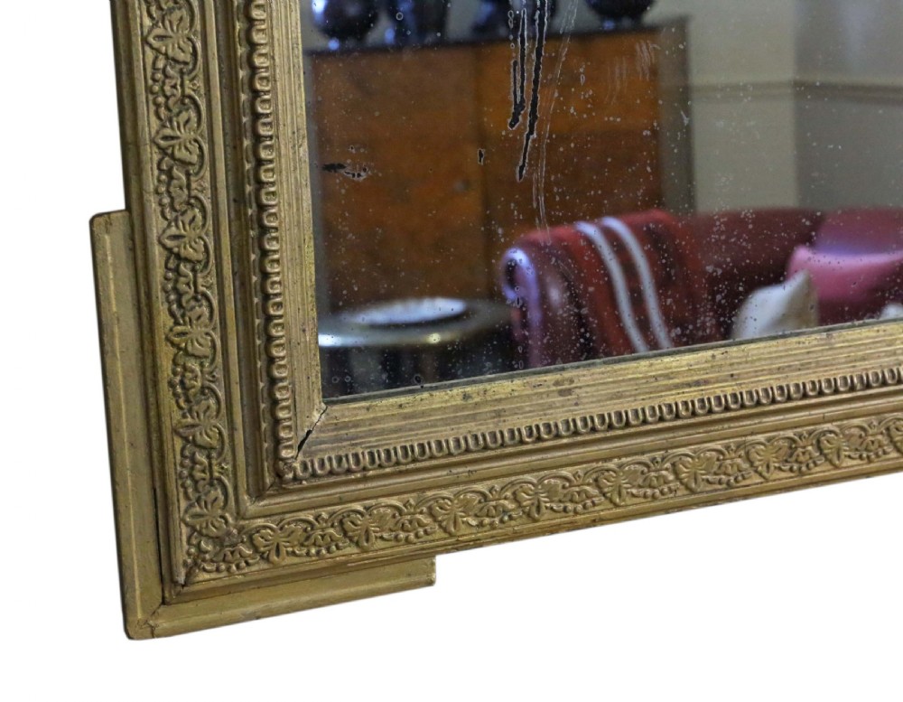 A tall 19th-century rectangular giltwood overmantel mirror featuring an ornate acanthus leaf crest and decorative moulded frame. View VIII