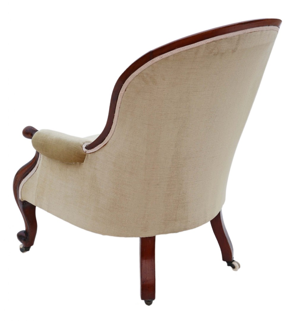 A Victorian mahogany spoon-back armchair featuring deep-buttoned beige velvet upholstery and cabriole front legs with castors. View II