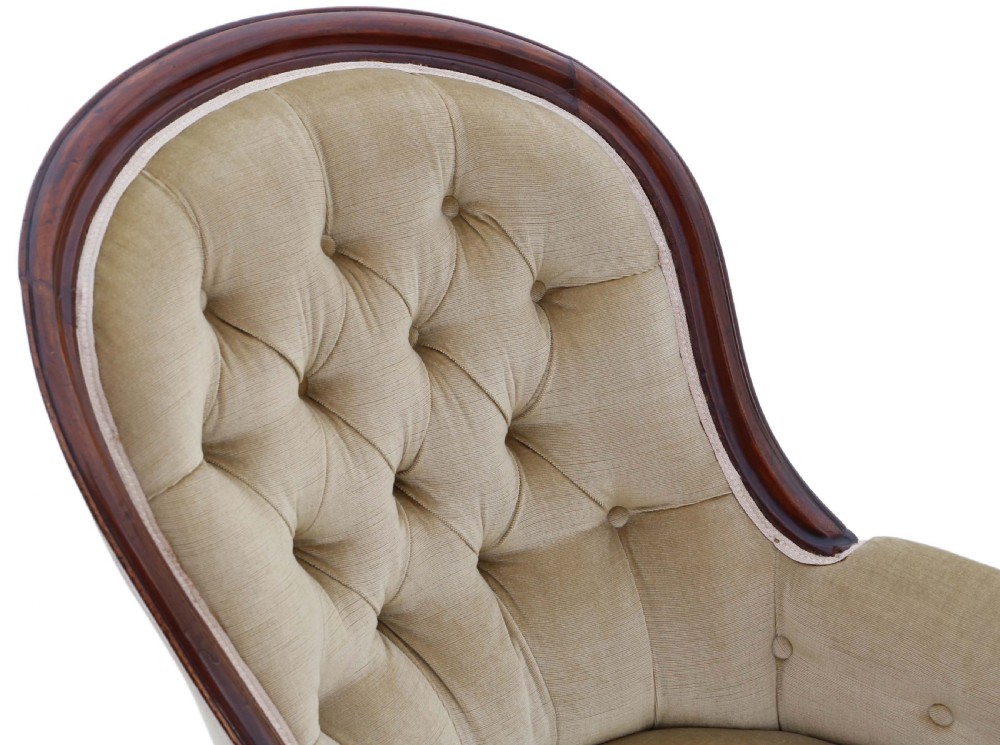 A Victorian mahogany spoon-back armchair featuring deep-buttoned beige velvet upholstery and cabriole front legs with castors. View V