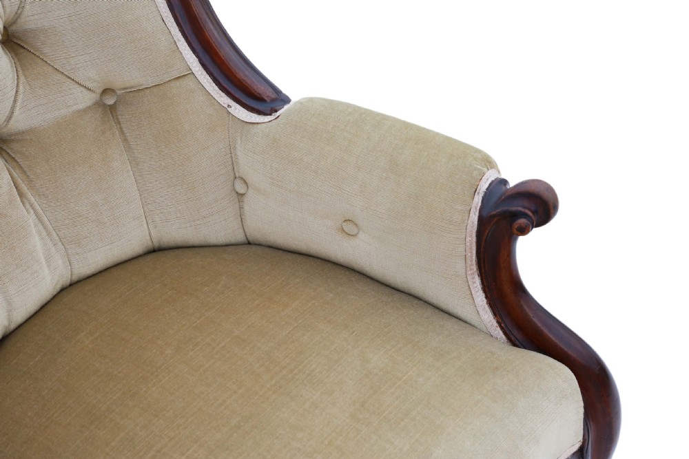 A Victorian mahogany spoon-back armchair featuring deep-buttoned beige velvet upholstery and cabriole front legs with castors. View VII