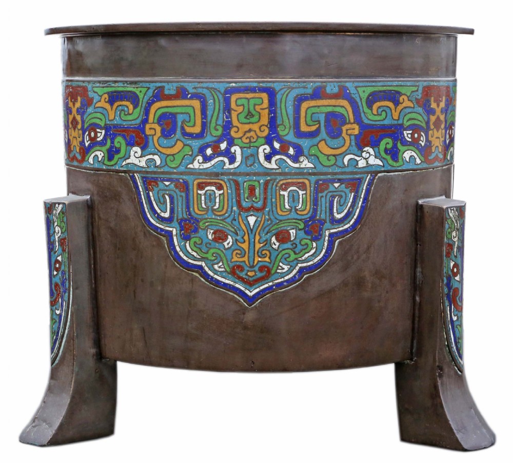 A large dark bronze planter decorated with colourful champleve enamel scroll patterns, supported by four cast feet.
