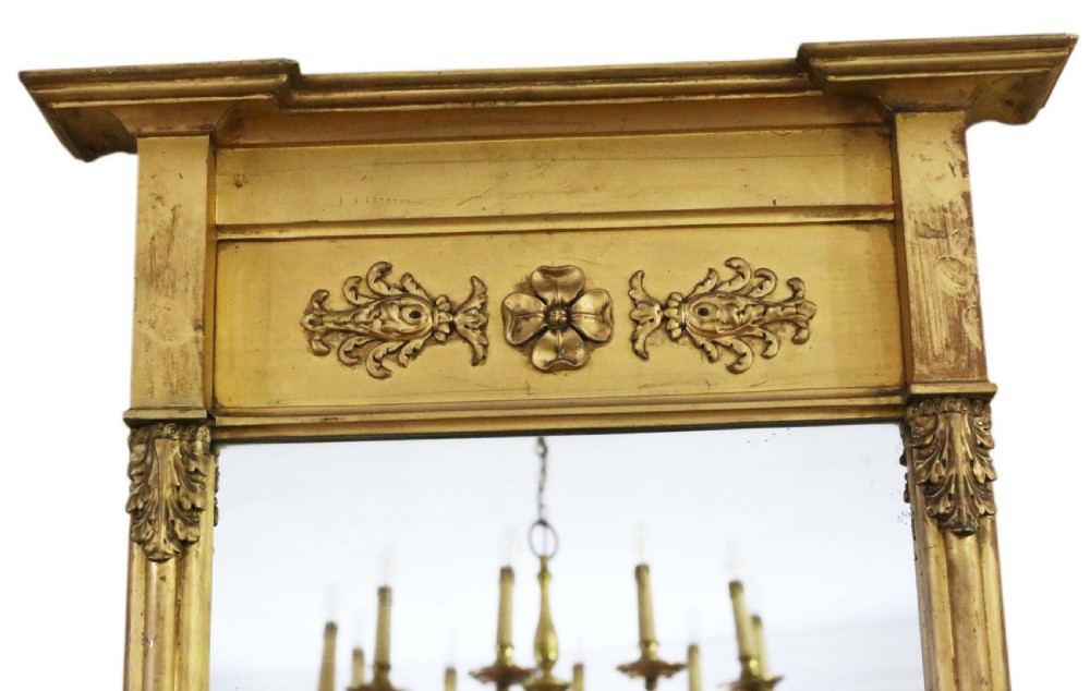 A tall 19th-century giltwood pier mirror featuring a protruding top cornice, a carved floral frieze, and side pilasters with acanthus leaf motifs. View II