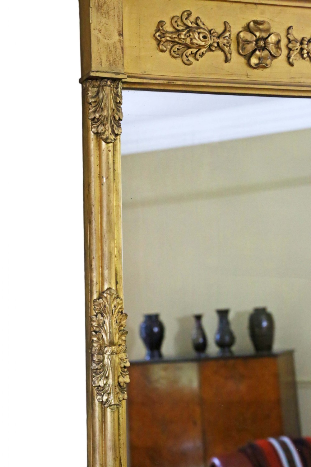A tall 19th-century giltwood pier mirror featuring a protruding top cornice, a carved floral frieze, and side pilasters with acanthus leaf motifs. View III