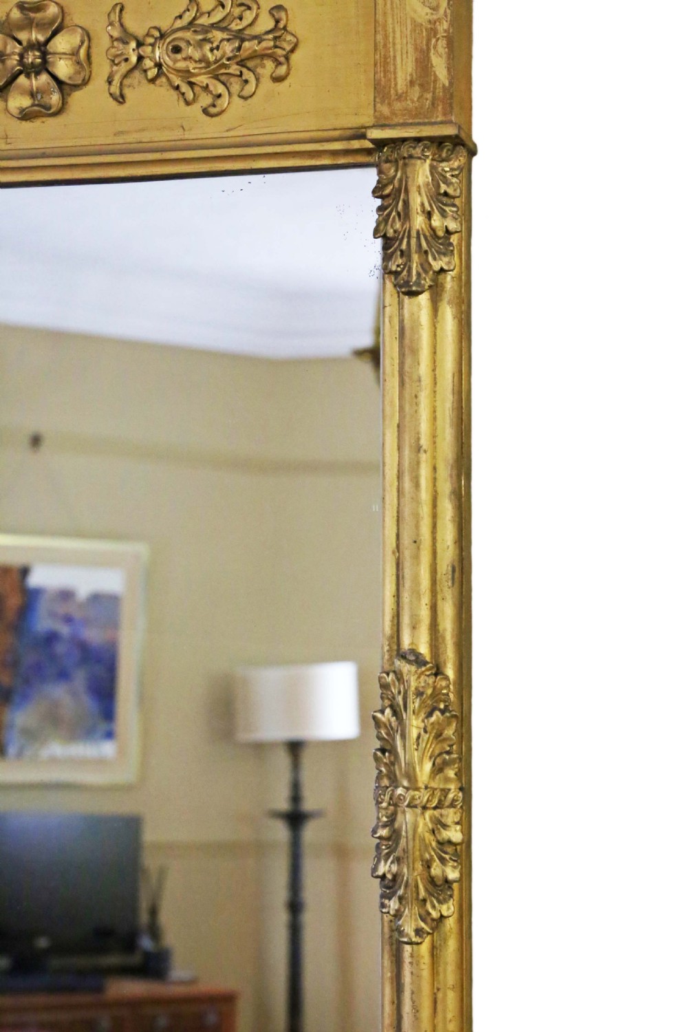 A tall 19th-century giltwood pier mirror featuring a protruding top cornice, a carved floral frieze, and side pilasters with acanthus leaf motifs. View IV