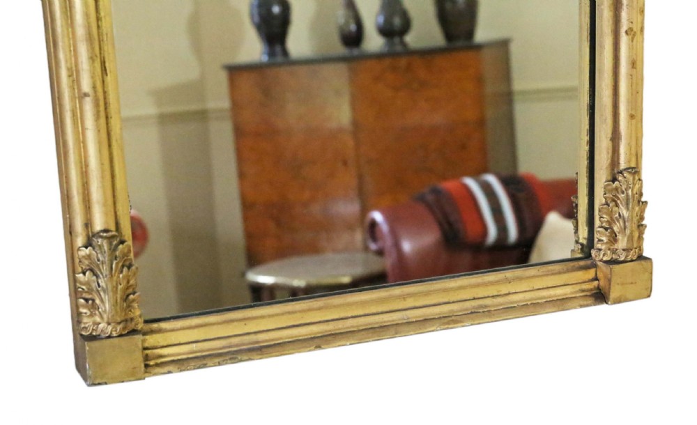 A tall 19th-century giltwood pier mirror featuring a protruding top cornice, a carved floral frieze, and side pilasters with acanthus leaf motifs. View V