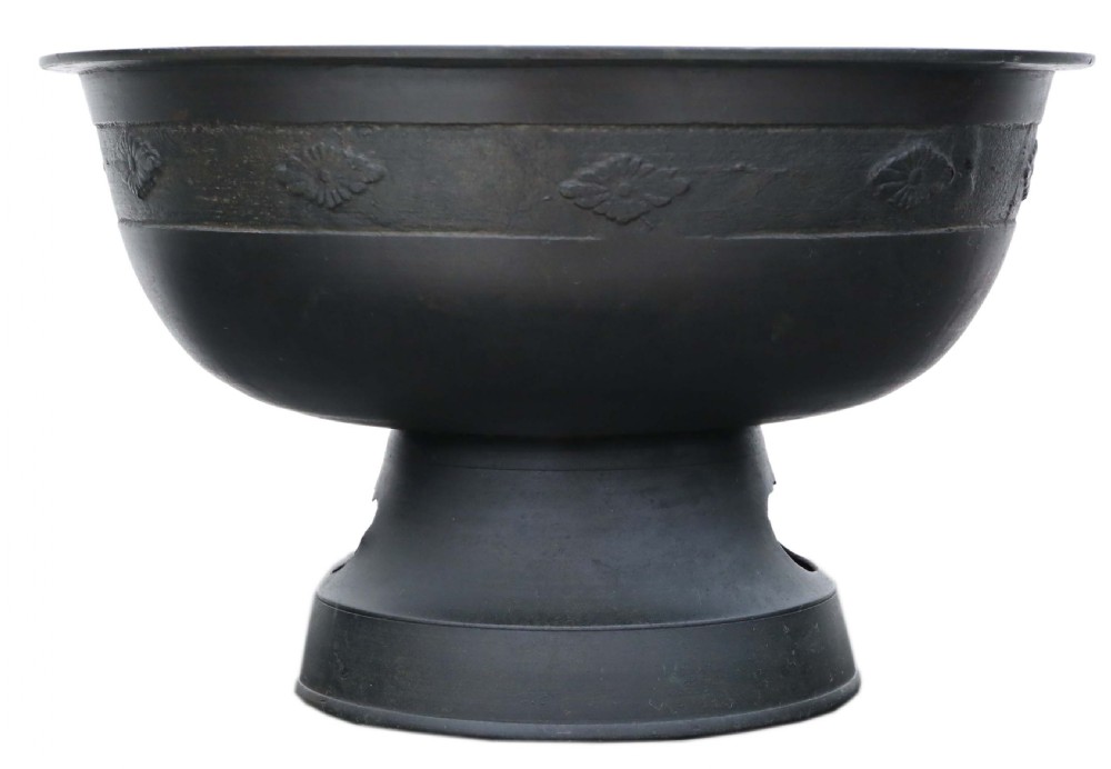 A dark bronze Japanese Edo period vessel featuring a flared rim with floral relief bands set upon a flared pedestal base.