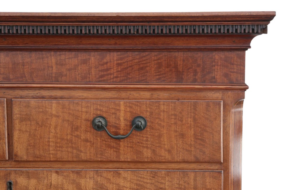 A nineteenth-century mahogany tallboy chest on chest featuring figured wood drawer fronts, brass drop handles, a dentil cornice, and splayed bracket feet. View II