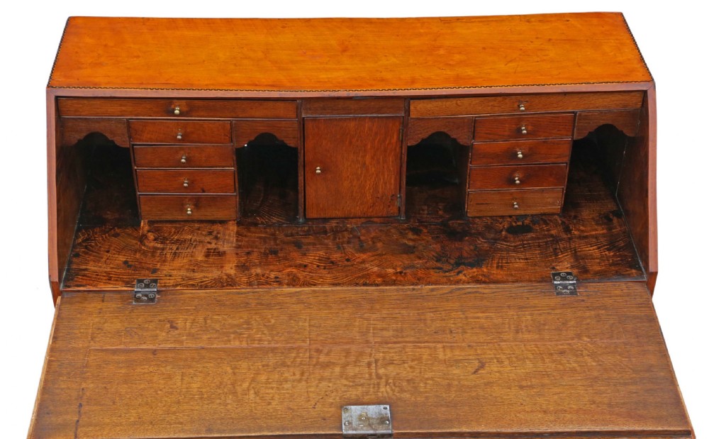 An 18th-century Georgian satin walnut bureau featuring a sloping fall-front lid with central oval inlay over four drawers with decorative brass swan-neck handles, resting on bracket feet. View III