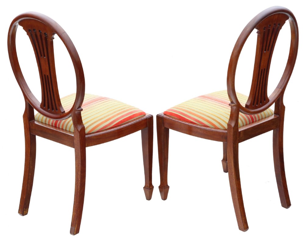 A pair of Edwardian Georgian Revival mahogany side chairs with circular backrests, carved central splats, satinwood marquetry inlays, and striped fabric seats. View II