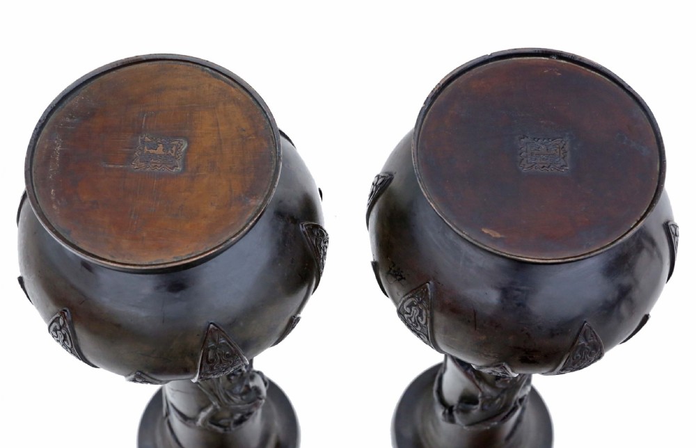 A pair of large 19th-century Japanese bronze vases decorated with high-relief bird and blossom carvings on cylindrical necks above pattern-embossed bulbous bases. View V