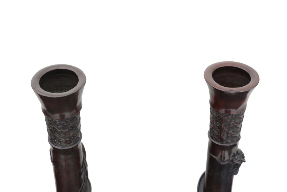 A pair of tall 19th-century Japanese bronze vases with relief-carved dragons coiling around slender necks and bird motifs on rounded bases. View III