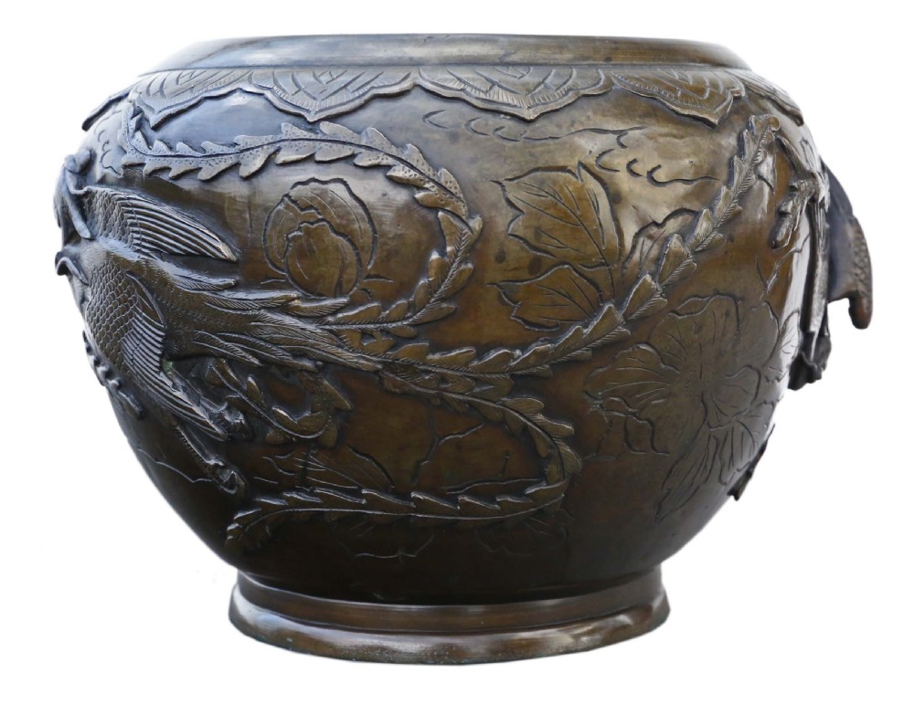 A bulbous dark bronze jardiniere decorated with high-relief carvings of birds among foliage and a stylized border around the rim. View III