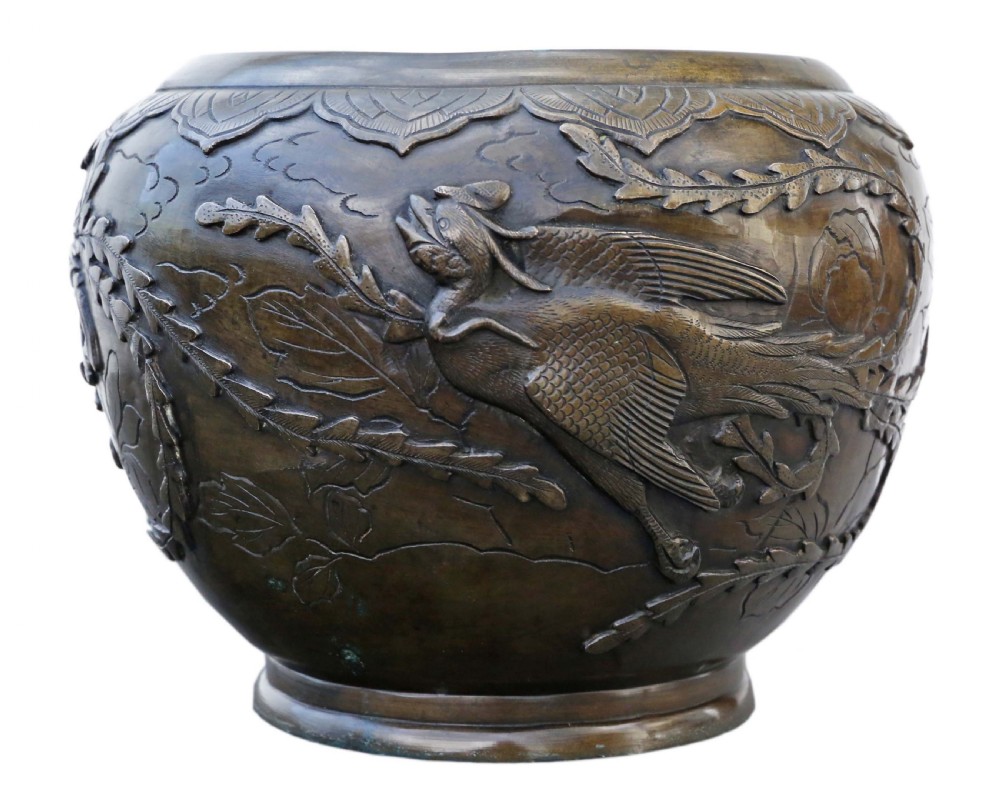 A bulbous dark bronze jardiniere decorated with high-relief carvings of birds among foliage and a stylized border around the rim. View IV