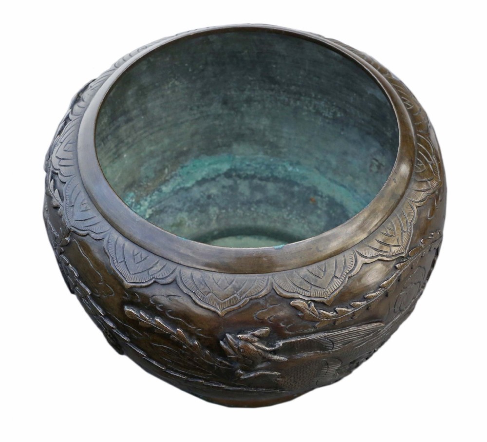 A bulbous dark bronze jardiniere decorated with high-relief carvings of birds among foliage and a stylized border around the rim. View V