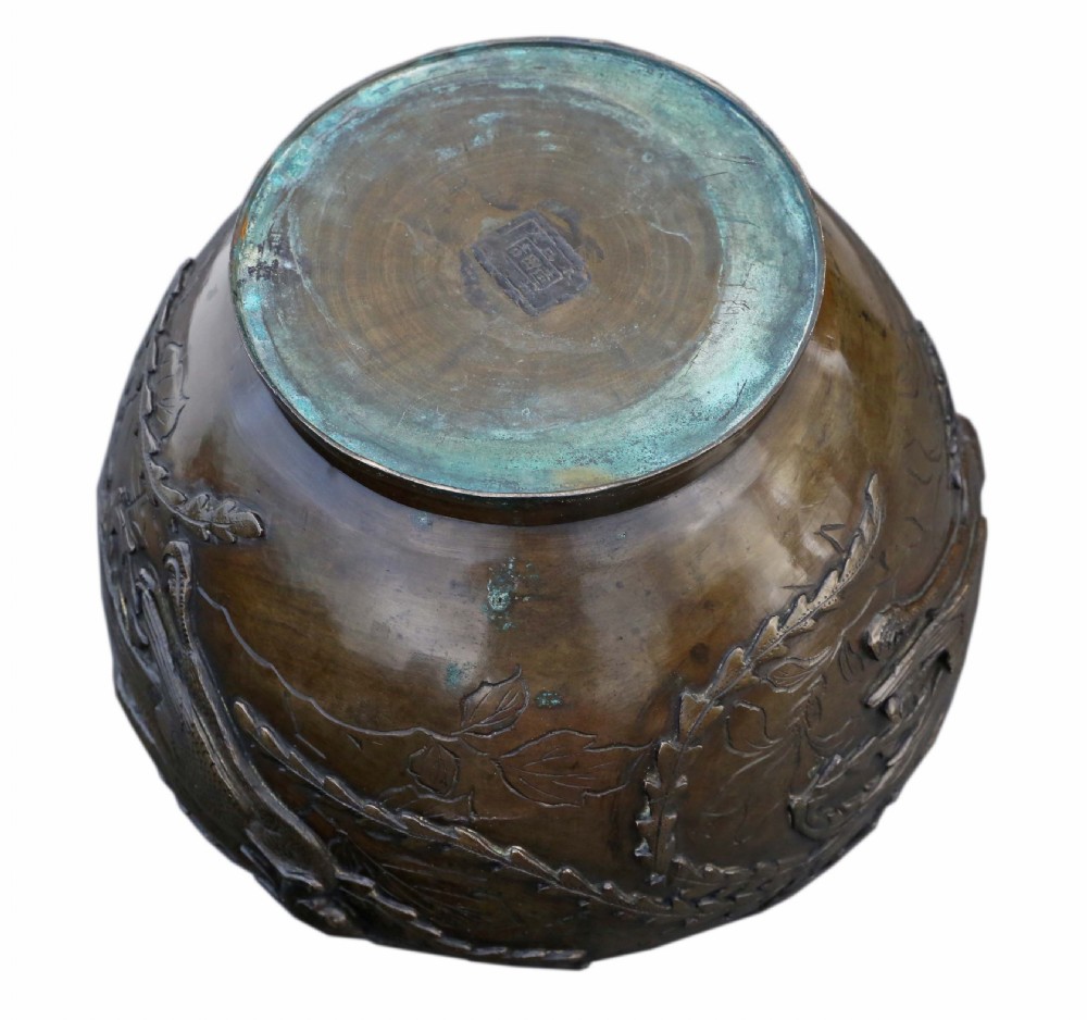 A bulbous dark bronze jardiniere decorated with high-relief carvings of birds among foliage and a stylized border around the rim. View VI