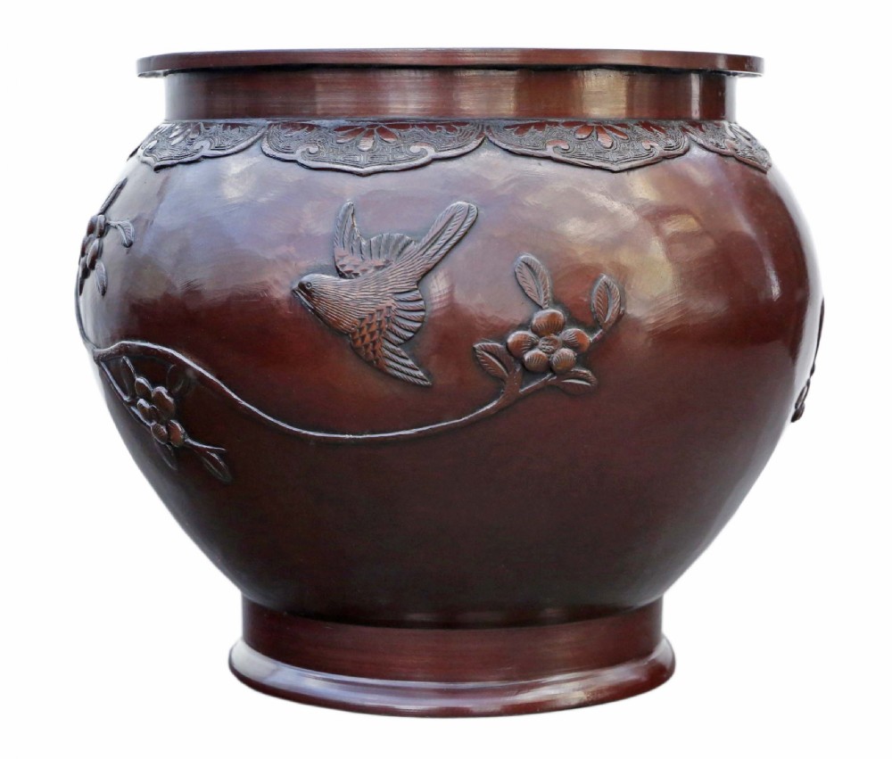 A dark brown patinated Japanese bronze jardiniere featuring high-relief relief carvings of birds perched on flowering branches. View II