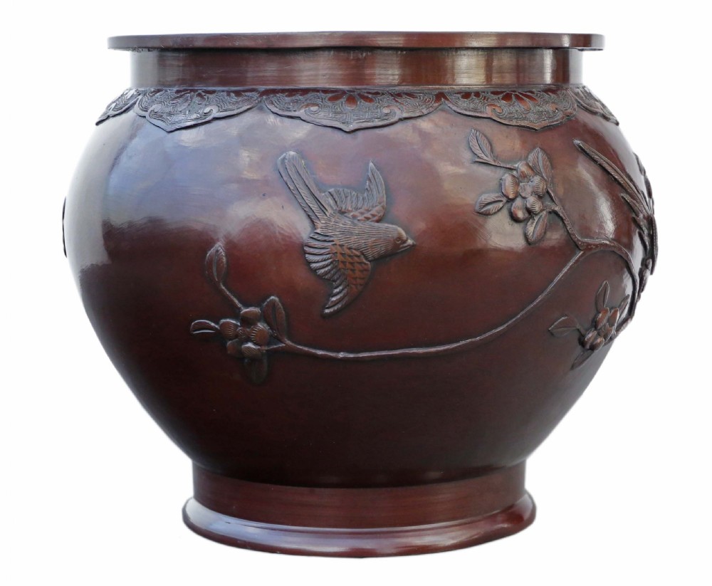 A dark brown patinated Japanese bronze jardiniere featuring high-relief relief carvings of birds perched on flowering branches. View V