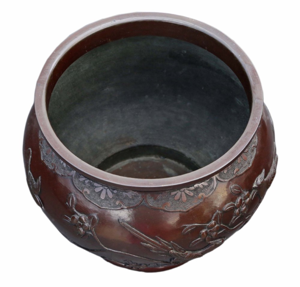 A dark brown patinated Japanese bronze jardiniere featuring high-relief relief carvings of birds perched on flowering branches. View VI