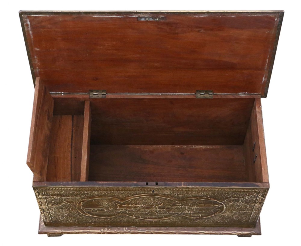 A rectangular wooden storage chest fully encased in hand-embossed brass sheeting featuring Chinoiserie landscape scenes and foliate borders. View V