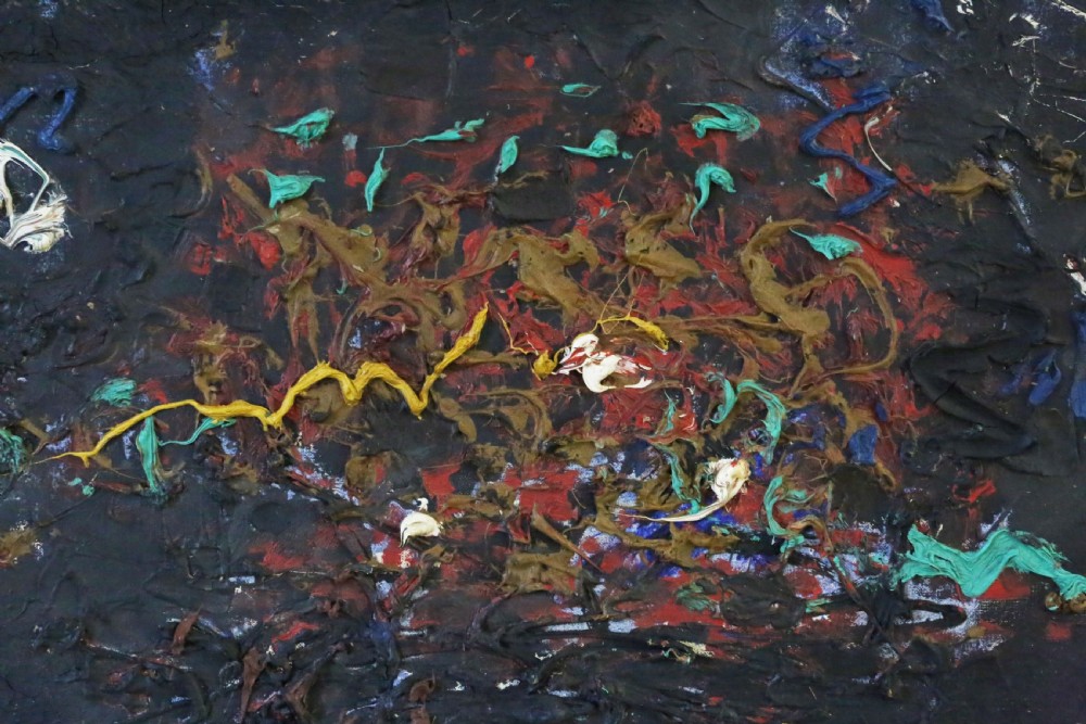 A rectangular mid-century abstract painting featuring heavy impasto paint relief in blue, yellow, red, and white across a dark textured background, enclosed in a slim wooden frame. View V