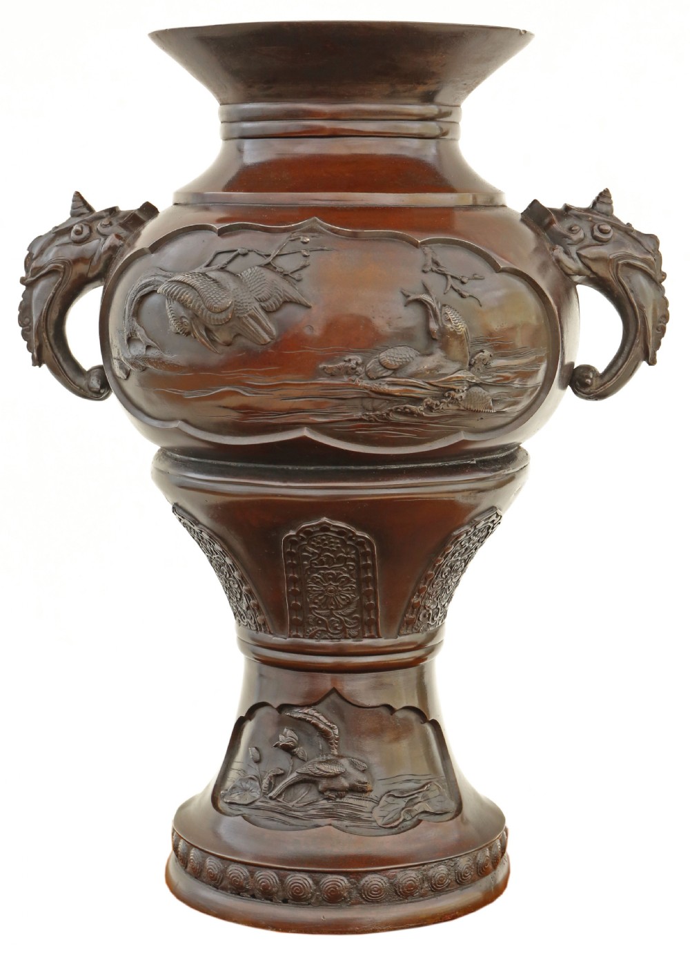 A large 19th-century Japanese Meiji period patinated bronze urn featuring relief-carved avian panels, twin beast-head handles, and a stepped circular pedestal base.