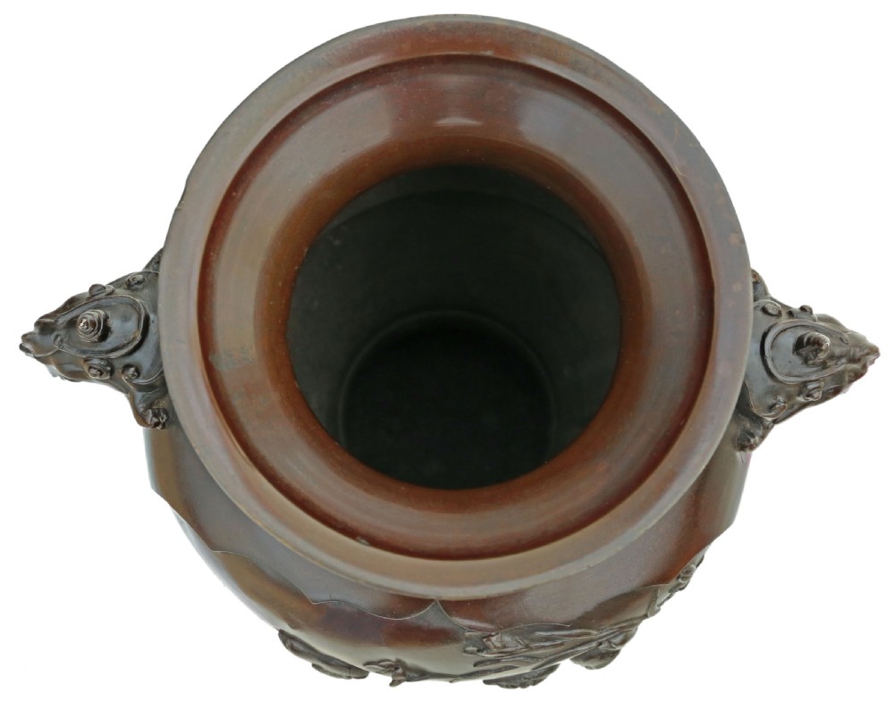 A large 19th-century Japanese Meiji period patinated bronze urn featuring relief-carved avian panels, twin beast-head handles, and a stepped circular pedestal base. View V