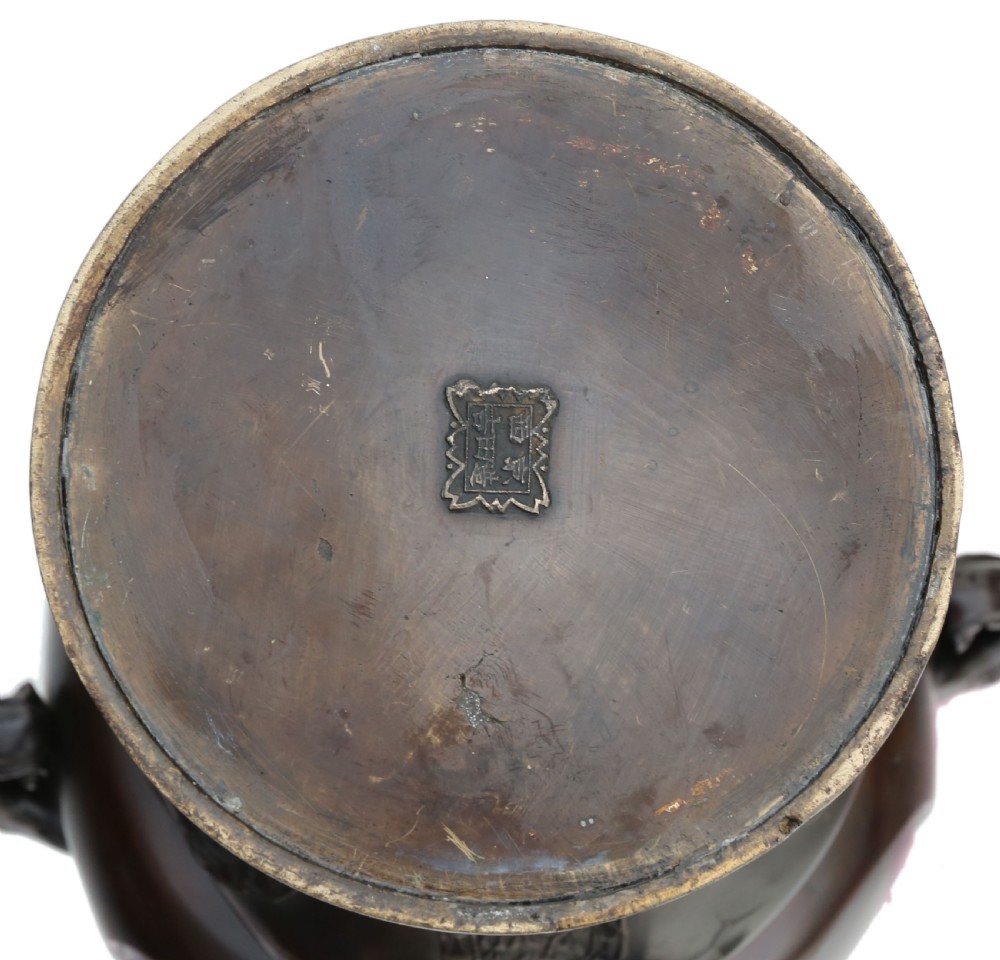 A large 19th-century Japanese Meiji period patinated bronze urn featuring relief-carved avian panels, twin beast-head handles, and a stepped circular pedestal base. View VI