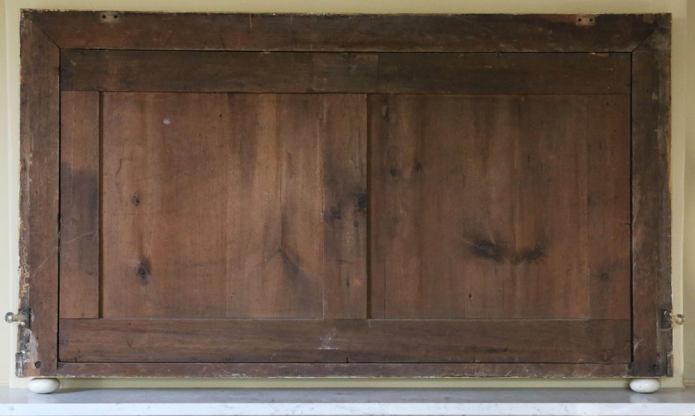A large rectangular 19th-century giltwood overmantel wall mirror featuring carved foliage corners and a foxed glass plate resting on ceramic feet. View V