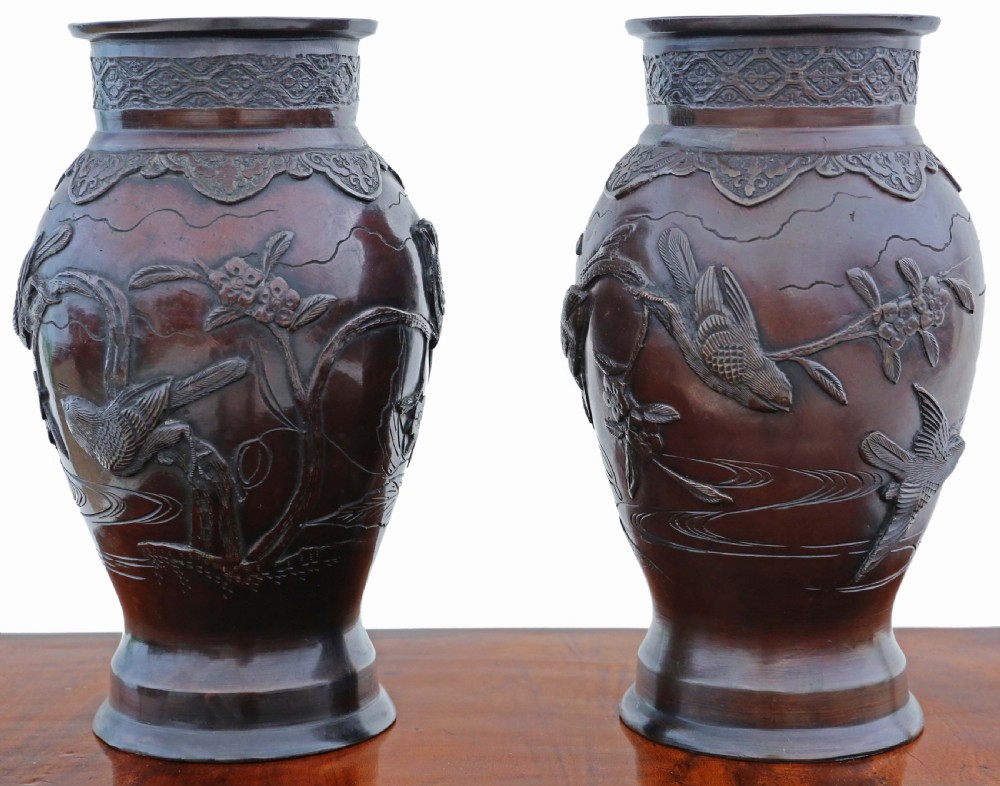 A pair of dark brown patinated Japanese Meiji period bronze vases featuring high relief carvings of birds perched on branches with geometric borders. View II
