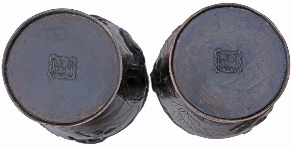 A pair of dark brown patinated Japanese Meiji period bronze vases featuring high relief carvings of birds perched on branches with geometric borders. View V