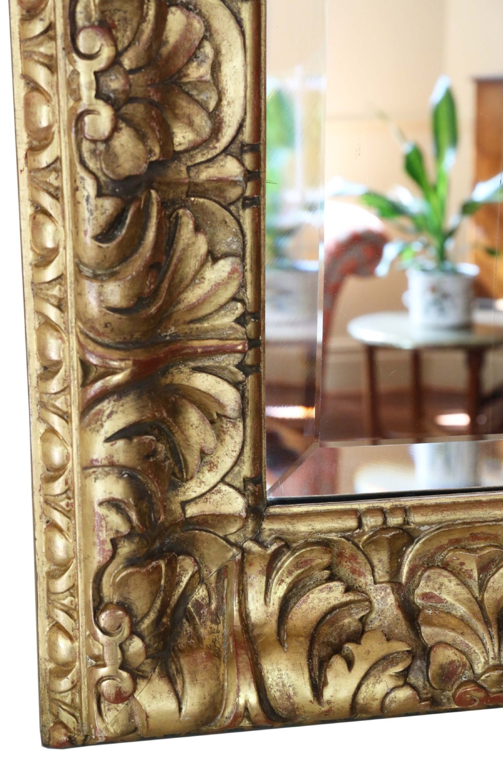 A rectangular gilded wall mirror featuring a carved leaf motif border with bevelled edge mirror glass. View II
