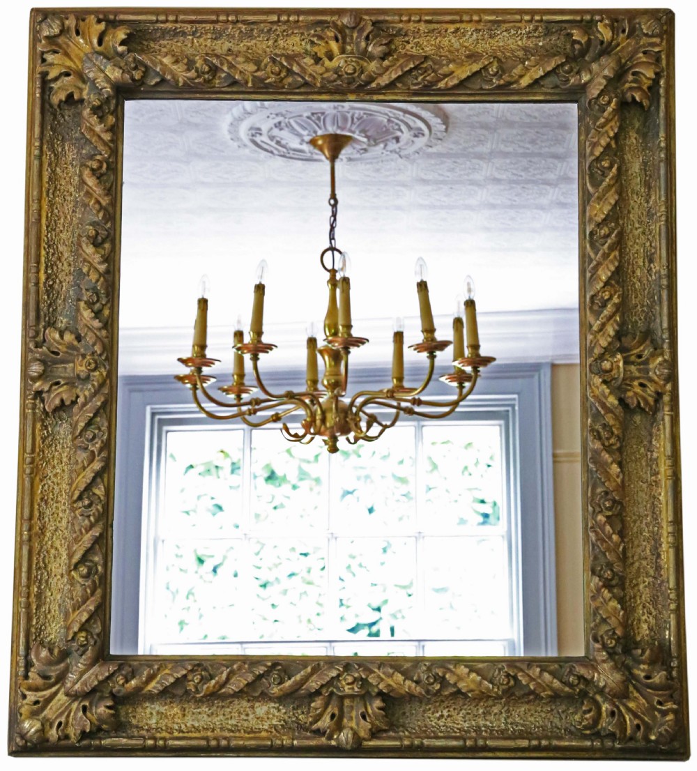 A large rectangular 19th-century wall mirror featuring a heavily carved giltwood frame decorated with acanthus leaf motifs.