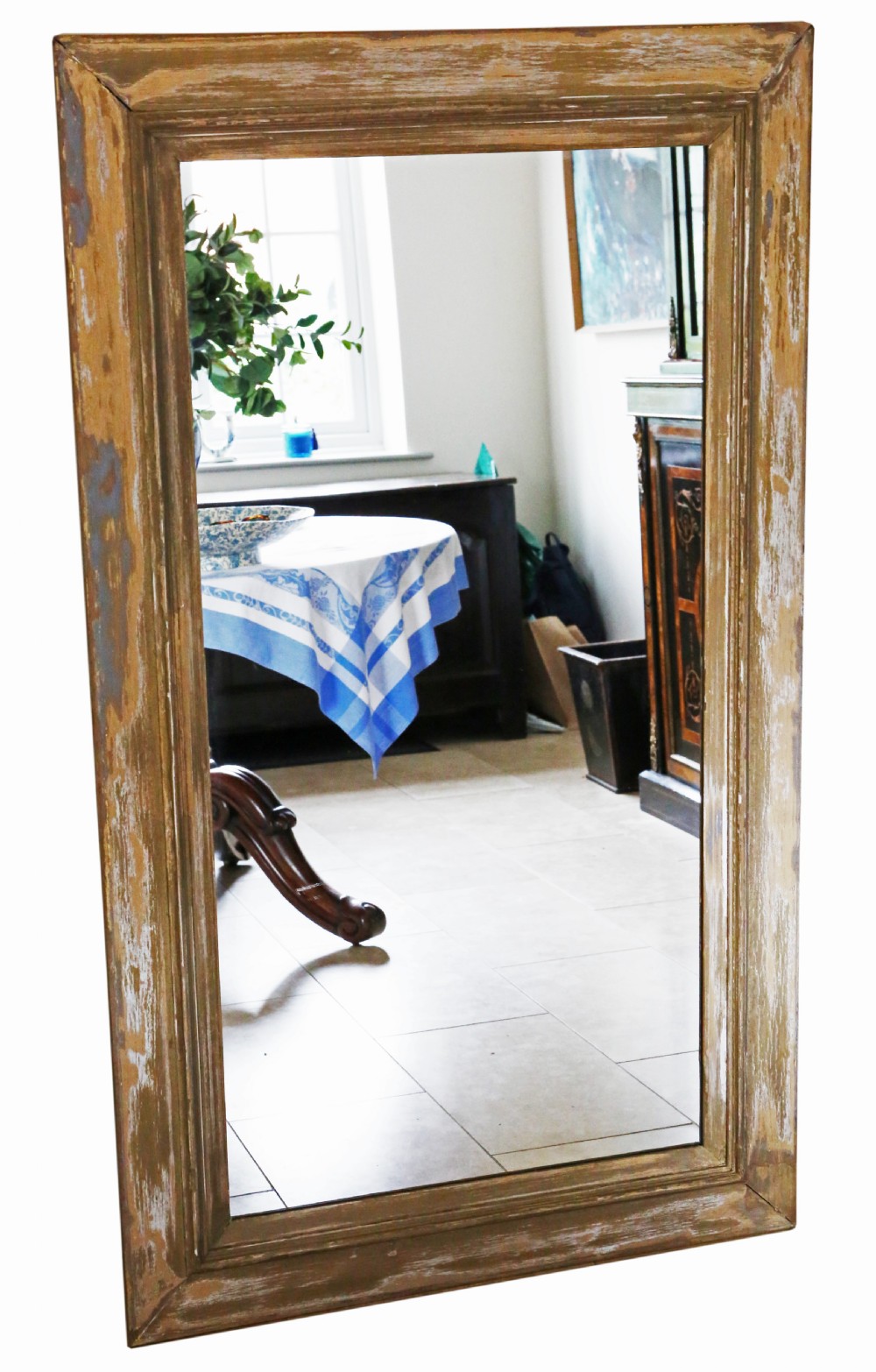 A large rectangular 19th-century wall mirror with a thick, distressed wooden frame displaying exposed wood and worn paint finish.