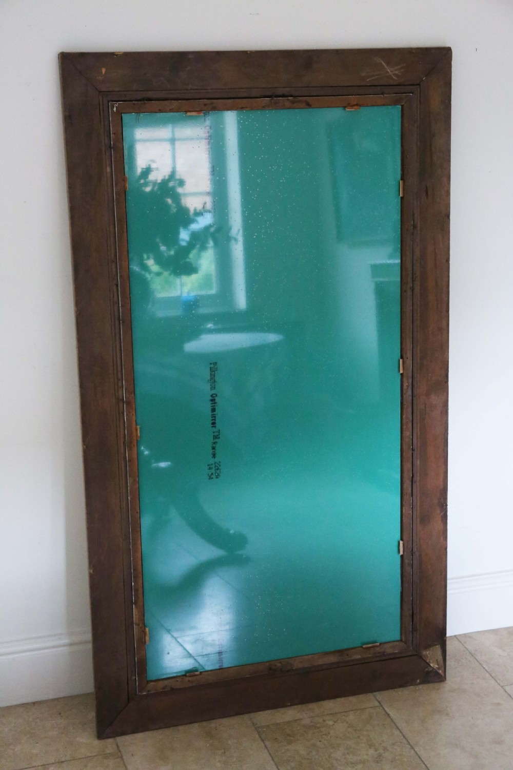 A large rectangular 19th-century wall mirror with a thick, distressed wooden frame displaying exposed wood and worn paint finish. View V