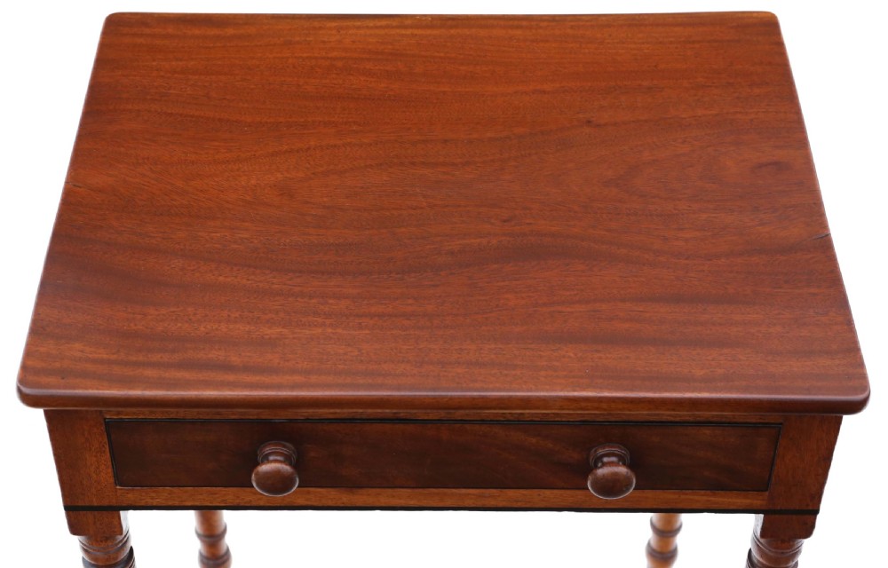 A 19th-century mahogany writing table featuring a single drawer with twin wooden knobs, set upon slender turned legs terminating in brass castors. View II