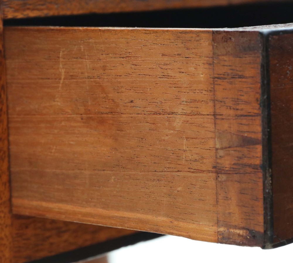 A 19th-century mahogany writing table featuring a single drawer with twin wooden knobs, set upon slender turned legs terminating in brass castors. View III