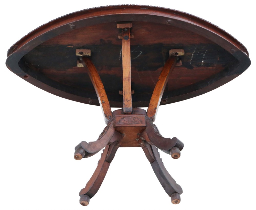 An antique Anglo-Indian carved wooden occasional table with a shield-shaped top featuring a starburst pattern on a pedestal base. View V
