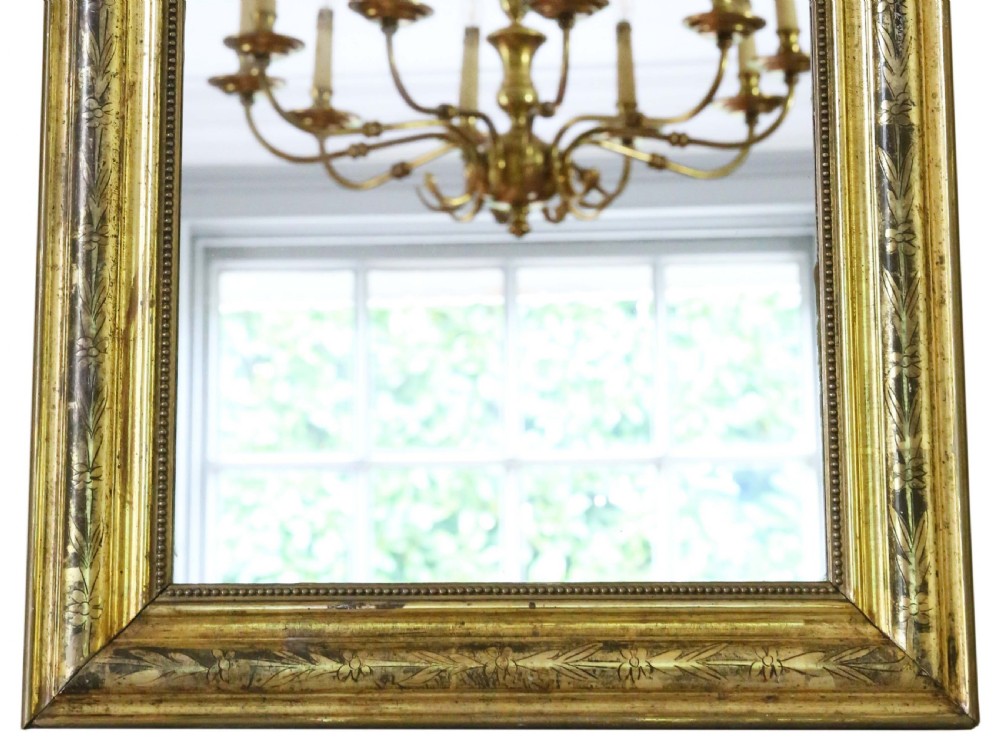 A nineteenth-century French Louis Philippe overmantel wall mirror featuring a gilt frame with rounded upper corners, engraved foliage motifs, and a beaded inner moulding. View III