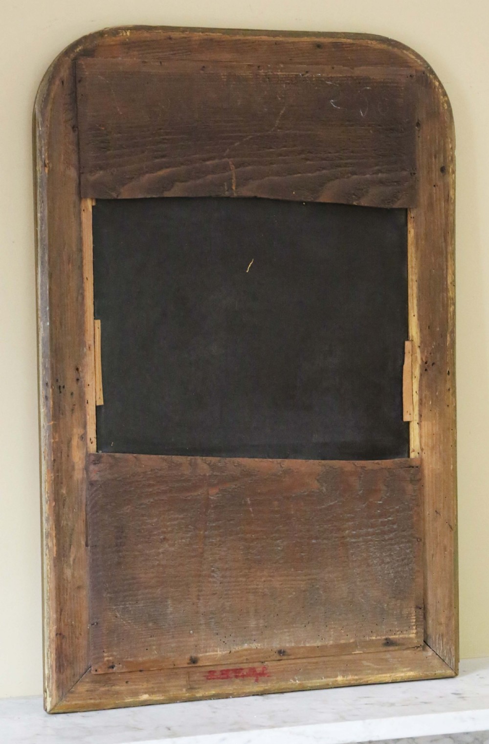 A nineteenth-century French Louis Philippe overmantel wall mirror featuring a gilt frame with rounded upper corners, engraved foliage motifs, and a beaded inner moulding. View V