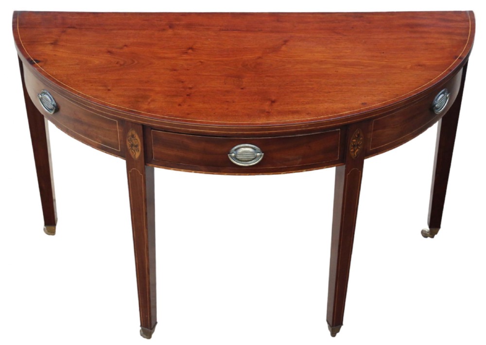 An early nineteenth-century semi-circular mahogany console table featuring line inlay, central drawers with brass ring handles, floral urn marquetry, and square tapered legs on brass castors. View II