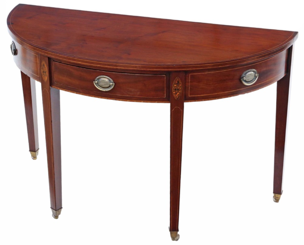 An early nineteenth-century semi-circular mahogany console table featuring line inlay, central drawers with brass ring handles, floral urn marquetry, and square tapered legs on brass castors. View IV