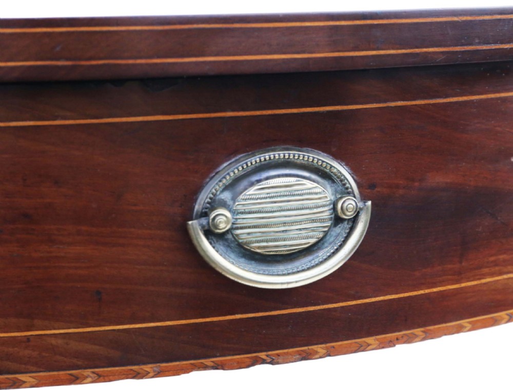 An early nineteenth-century semi-circular mahogany console table featuring line inlay, central drawers with brass ring handles, floral urn marquetry, and square tapered legs on brass castors. View VI